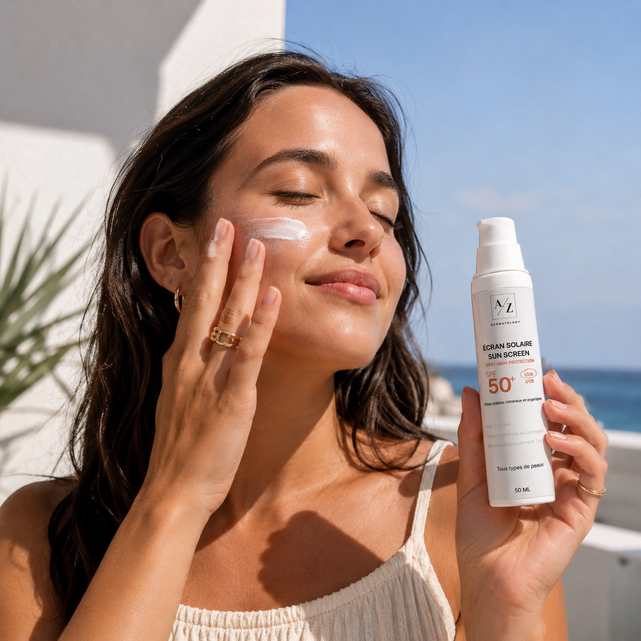 Femme appliquant l’écran solaire anti-taches A to Z Dermatology SPF 50+